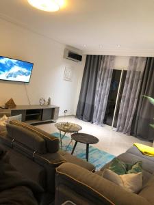 a living room with a couch and a flat screen tv at Asilah Marina Golf Sea Ocean and Golf view in Asilah +77 photos