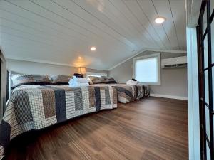 two beds in a room with wood floors at Retreat on the Lake in Hiawassee