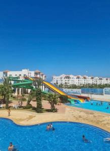 a pool at a resort with a water slide at Asilah Marina Golf Sea Ocean and Golf view in Asilah