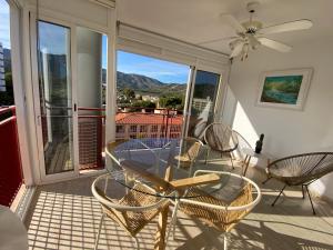 eine Terrasse mit einem Glastisch und Stühlen auf dem Balkon in der Unterkunft Apartamento en Voramar a 2 minutos de la playa in Benicàssim