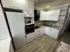 a kitchen with white cabinets and a microwave at Apartment on Vatutina in Vinnytsya