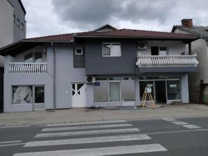 a white house with a crosswalk in front of it at Apartment Edin in Bihać