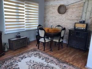 una sala da pranzo con tavolo e sedie e un muro di mattoni di TARİHİ KALEİÇİ DENİZE YAKIN SİZE ÖZEL MUHTEŞEM KONUM UYGUN FİYAT ev a Antalya (Adalia)
