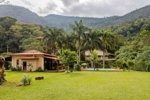 una casa con un gran patio con palmeras en Casa de campo Secretário/ Pedro do Rio RJ, en Petrópolis