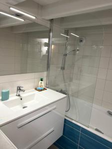 a white bathroom with a sink and a shower at Comme à la Maison - Terrasse et Jardinet- in Douarnenez +18 photos