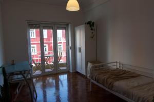 sypialnia z łóżkiem i przesuwnymi szklanymi drzwiami w obiekcie Lisbon Key Hub - Rooms 6-10 w Lizbonie