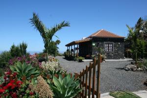 un jardín frente a una casa con flores en Fide, en Tijarafe