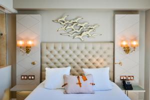 a bedroom with a bed with two pillows at Grand Hotel Des Sablettes Plage, Curio Collection By Hilton in La Seyne-sur-Mer