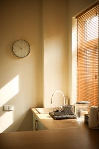 a kitchen with a sink and a clock on the wall at Ozolu apartment in Liepāja