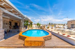a swimming pool on a wooden deck with a house at Masseria Le Dimore in Gallipoli