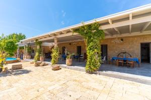 an outdoor patio with a pergola and tables and chairs at Masseria Le Dimore in Gallipoli