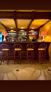 un bar con 4 sillas y una barra con botellas en Hotel Coral Beach en Roda