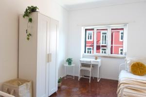 sypialnia z łóżkiem, biurkiem i oknem w obiekcie Lisbon Key Hub - Rooms 6-10 w Lizbonie