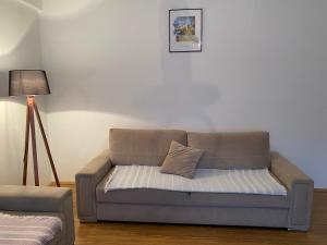 un sofá con una almohada en la sala de estar en Boulevard Mitrovica, en Kosovska Mitrovica