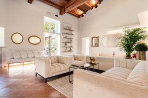 a living room with two couches and a table at Dimora Caiammari Luxury Hotel & Spa in Siracusa