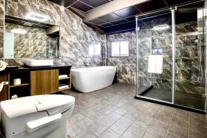 een badkamer met een douche, een toilet en een wastafel bij Yi MOTEL in Luodong