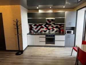 a kitchen with white cabinets and a stove at Апартаменти Східна Перлина in Vinnytsya