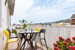 balcón con mesa, sillas y flores en Freshwater Pirates, en Gaeta