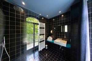 a black bathroom with a sink and a mirror at Hotel Sachsenklemme in Fortezza +98 photos
