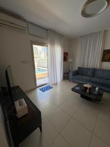 a living room with a blue couch and a table at Paez Villa in Protaras