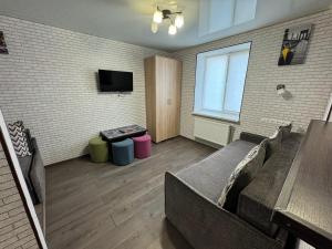 sala de estar con sofá y TV en Затишна квартира для Вашої родини en Vínnytsia