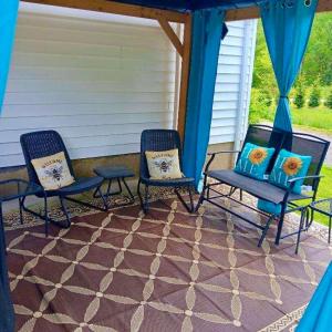 2 sillas y una mesa en el patio en Giggling Creek Cottage - BedJet! King Sized! Gazebo, 45 Acres, Arcades, Nintendo, more, en Henry