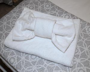 parę białych ręczników siedzących na łóżku w obiekcie SiricyAus w mieście Ragusa