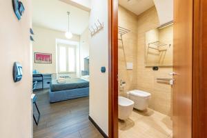 a bathroom with a toilet and a bed in a room at ANDENIS TIBER HOUSE in Rome