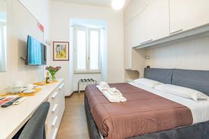 ein Schlafzimmer mit einem großen Bett und einem Schreibtisch in der Unterkunft ANDENIS TIBER HOUSE in Rom