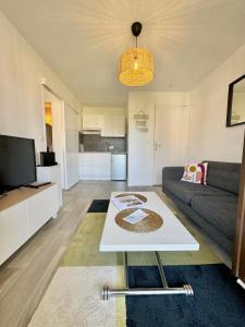 a living room with a couch and a table at Plage Cabourg 7bis in Cabourg