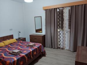 a bedroom with a bed and a dresser and a mirror at Pari Holiday Studio in Paphos