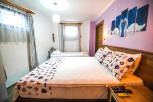 ボズジャ島にあるBozcaada Hotel Vitisのピンクの壁のベッドルーム1室(大型ベッド1台付)