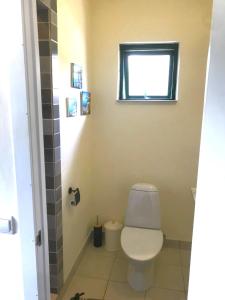 een badkamer met een toilet en een raam bij Vila da Paixão in Pedraça