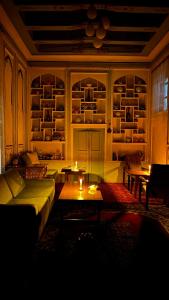 a living room with a couch and tables and shelves at Usman Heritage Hotel in Bukhara