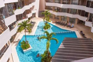una vista aérea de una piscina en un edificio con palmeras en Luxury 2-bed Apartment 200MB Wifi Sauna AC Gym en Playa del Carmen