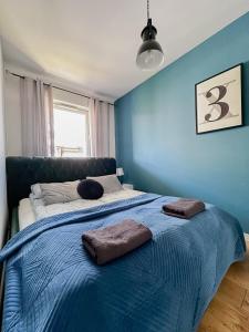 a blue bedroom with a bed with two pillows on it at Warsaw Inside Business Centre in Warsaw