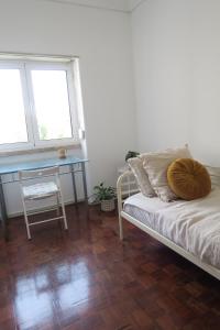sypialnia z łóżkiem i biurkiem oraz 2 oknami w obiekcie Lisbon Key Hub - Rooms 6-10 w Lizbonie