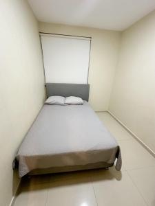 ein kleines Schlafzimmer mit einem Bett in einem Zimmer in der Unterkunft Departamento Deluxe in Piura