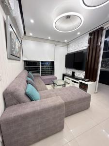 ein Wohnzimmer mit einem Sofa und einem Flachbild-TV in der Unterkunft Departamento Deluxe in Piura