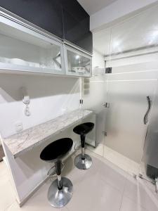ein weißes Badezimmer mit zwei Hockern und einer Theke in der Unterkunft Departamento Deluxe in Piura