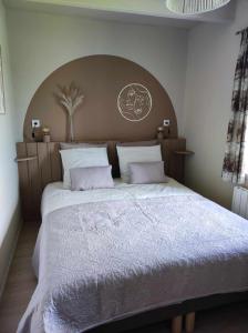 a large bed with a large headboard in a bedroom at Gîte Ar Friz Vihan in Briec