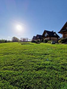 pole zielonej trawy z domem w tle w obiekcie Domki i Apartamenty Krupa Ciche w Zakopanem