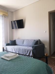 a living room with a couch and a flat screen tv at Karystos central apartment, near the beach in Karistos +36 photos