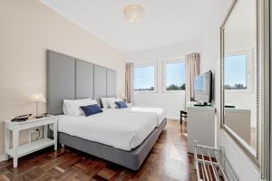 a bedroom with a large bed and a television at Lisboa Central Park Hotel Suites & Studios in Lisbon