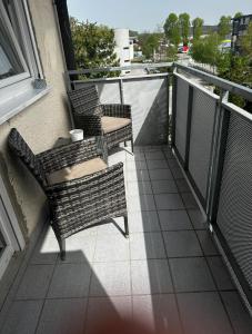 Duas cadeiras e uma mesa numa varanda em City Apartment Nord em Salzburgo