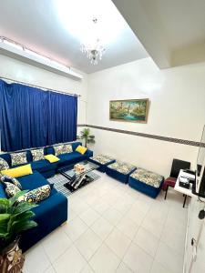 a living room with blue couches and a piano at Cente ville House in Agadir