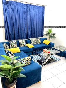 a blue couch with pillows and a table in a living room at Cente ville House in Agadir