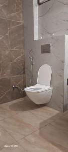 een badkamer met een toilet in de hoek van een kamer bij Angel Pink Residency B58 in Ghaziabad