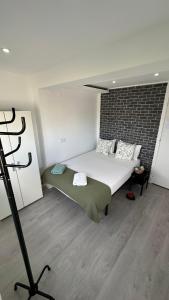 1 dormitorio con 1 cama grande y pared de ladrillo en Quarto Aeroporto en Lisboa