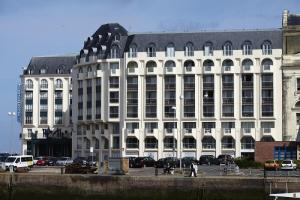 a large white building with cars parked in front of it at Résidence Le Beach - maeva Home - 2 Pièces 5 Personnes Confort 67 in Trouville-sur-Mer